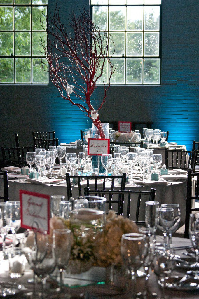Red coral branch centerpieces blue uplighting hanging candles