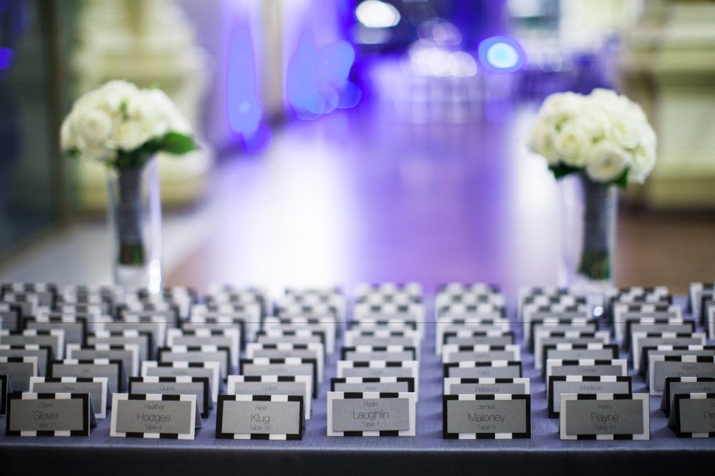 A table of lined up black and white striped escort cards for a wedding