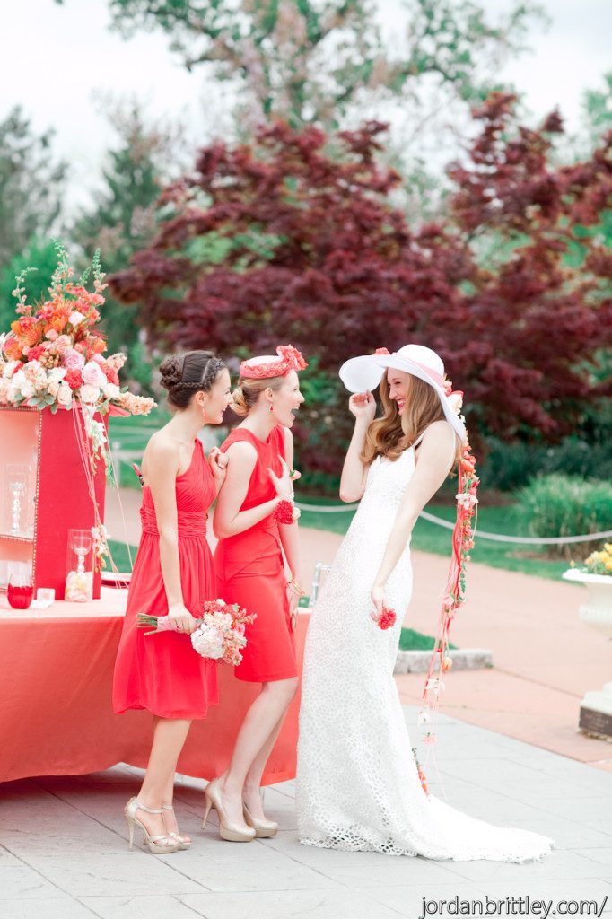 Bride with bridal hat and bridesmaids wearing red