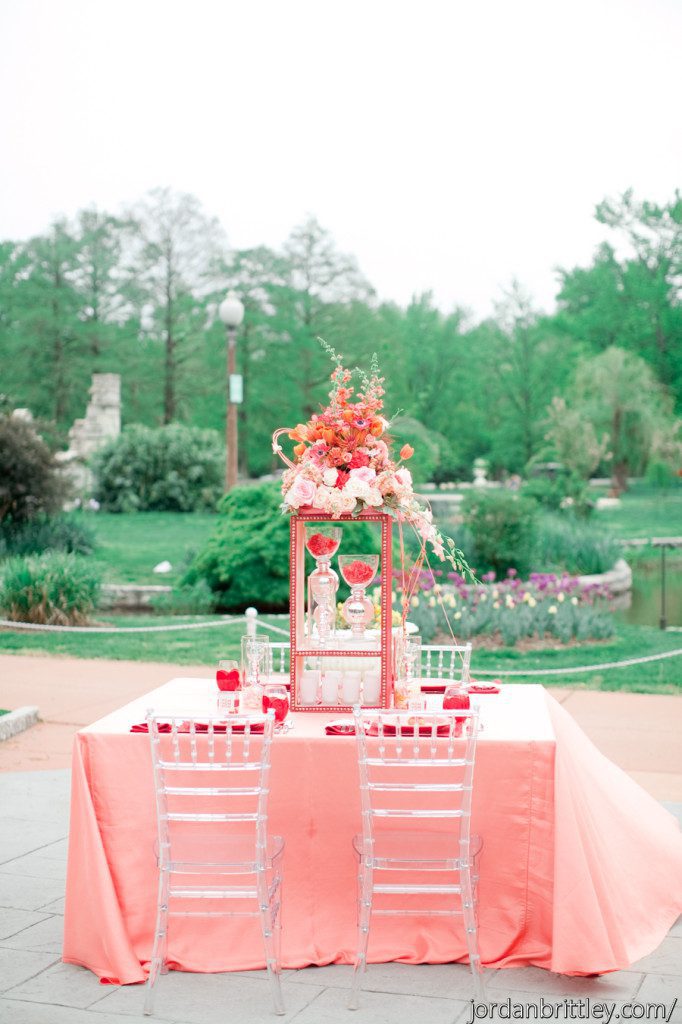 Unique centerpiece on custom stand on blush table linen and clear chiavari chairs