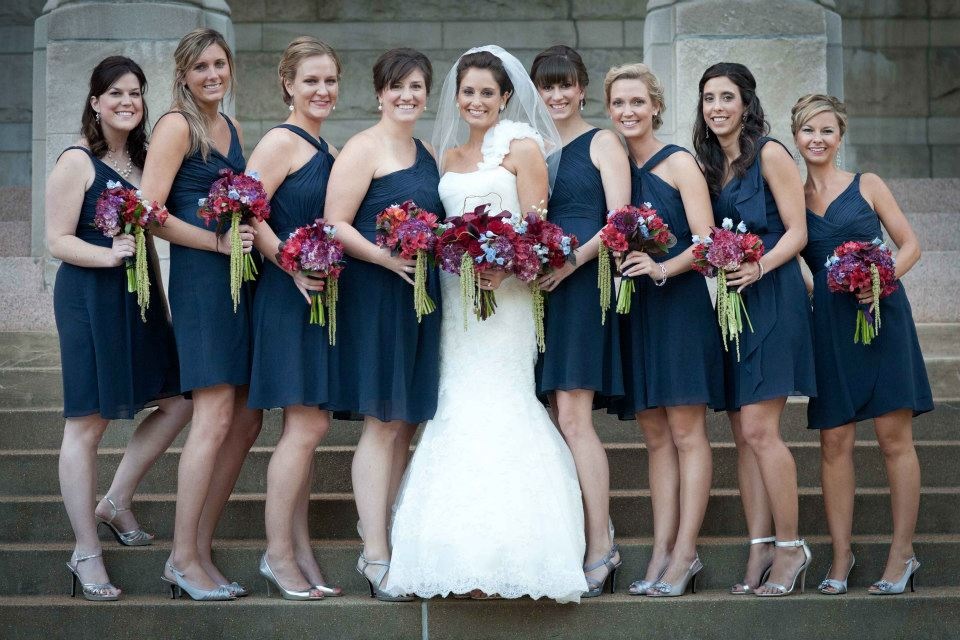 Dark blue bridesmaids with purple and red bouquets