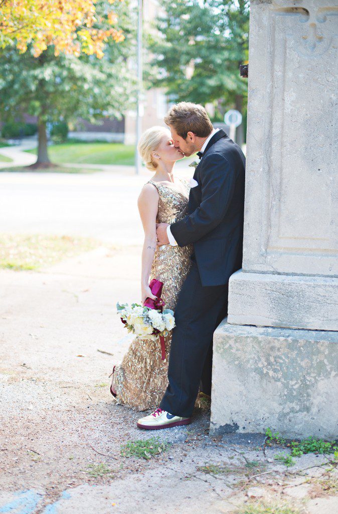 Bride and groom kissing at park gold sequin gown