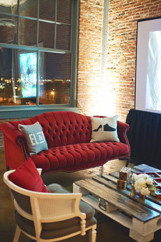 Dark red vintage couch with custom logo pillows wedding reception