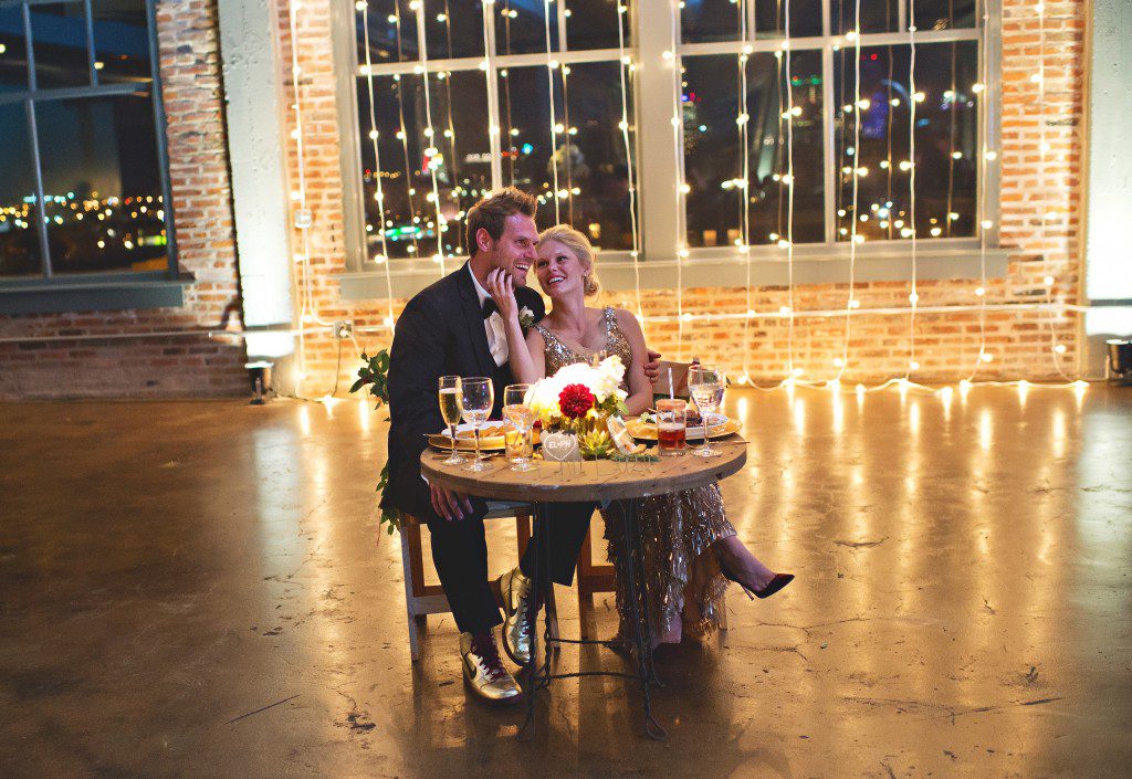 Sweetheart table and lightbulb backdrop